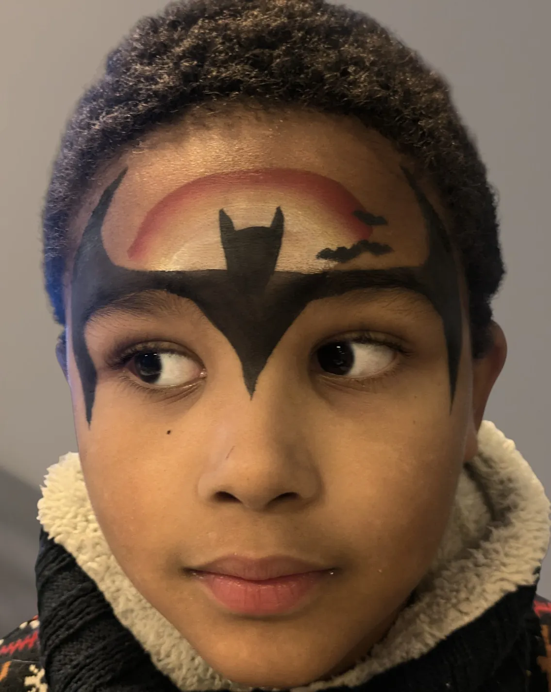 Maquillage artistique de super-héros réalisé sur un garçon